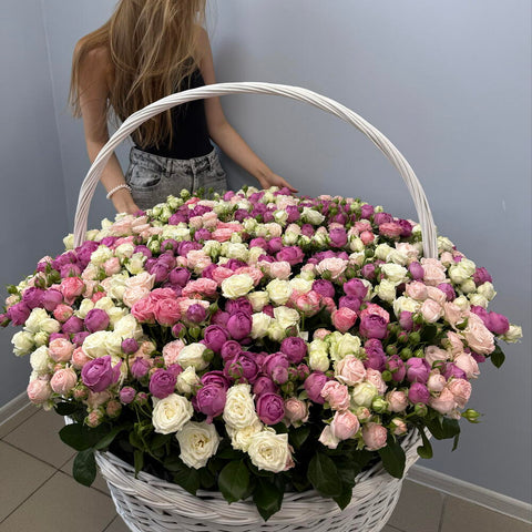 Woman behind a large basket of pink and cream roses