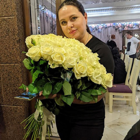 Woman holding a bouquet of white roses
