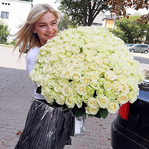 Woman smiling with a large bouquet of white roses