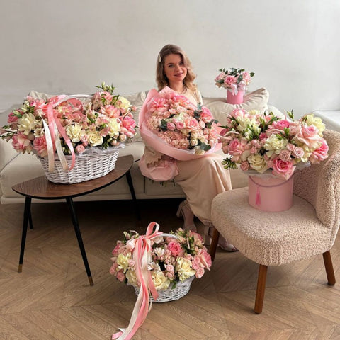 Woman surrounded by pink flower arrangements in a living room